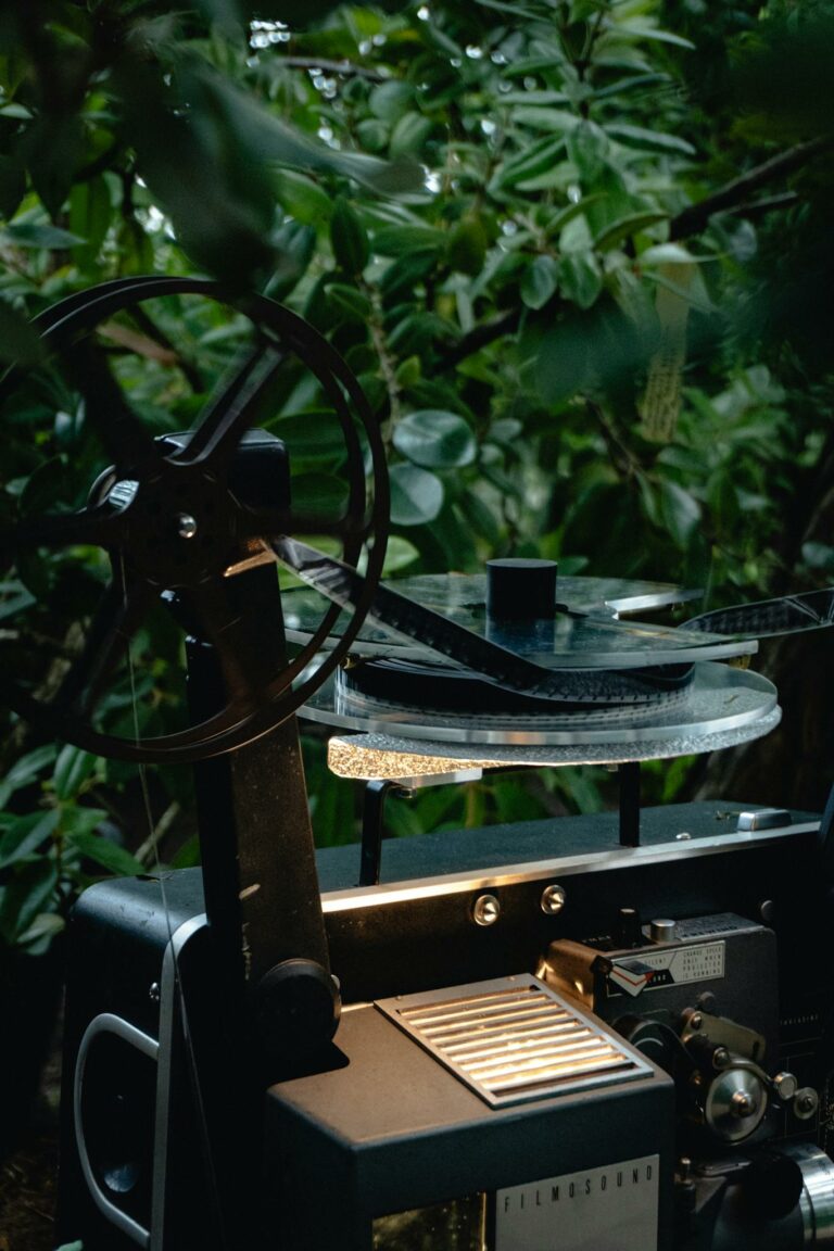 An atmospheric capture of an old vintage movie projector amidst lush greenery, evoking nostalgia.
